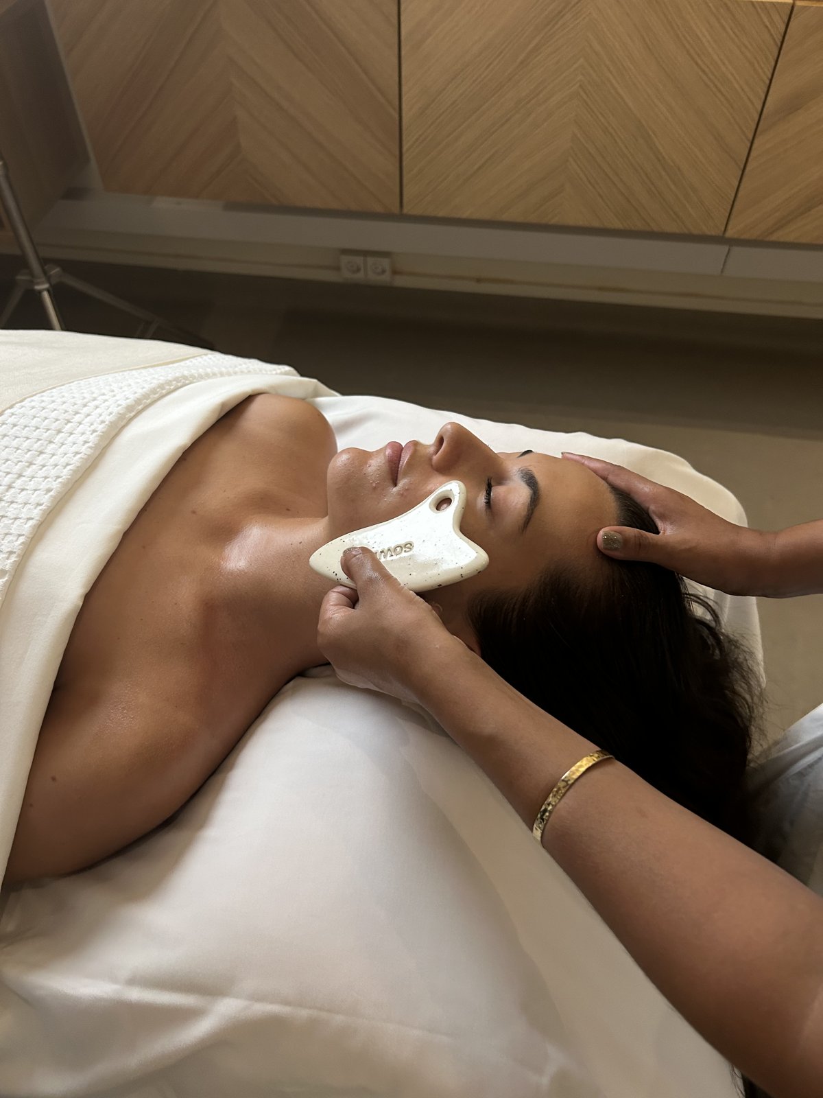 Facialist performing a facial treatment with the SOWÉ gua sha in a treatment room Image